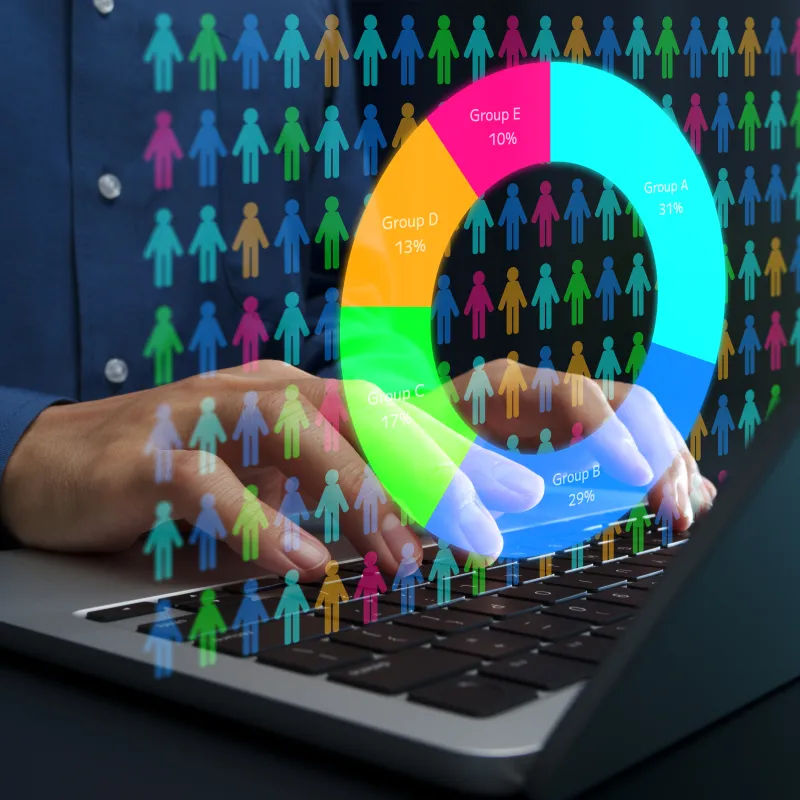 hands on a laptop keyboard overlaid with a graphic of demographic data analysis