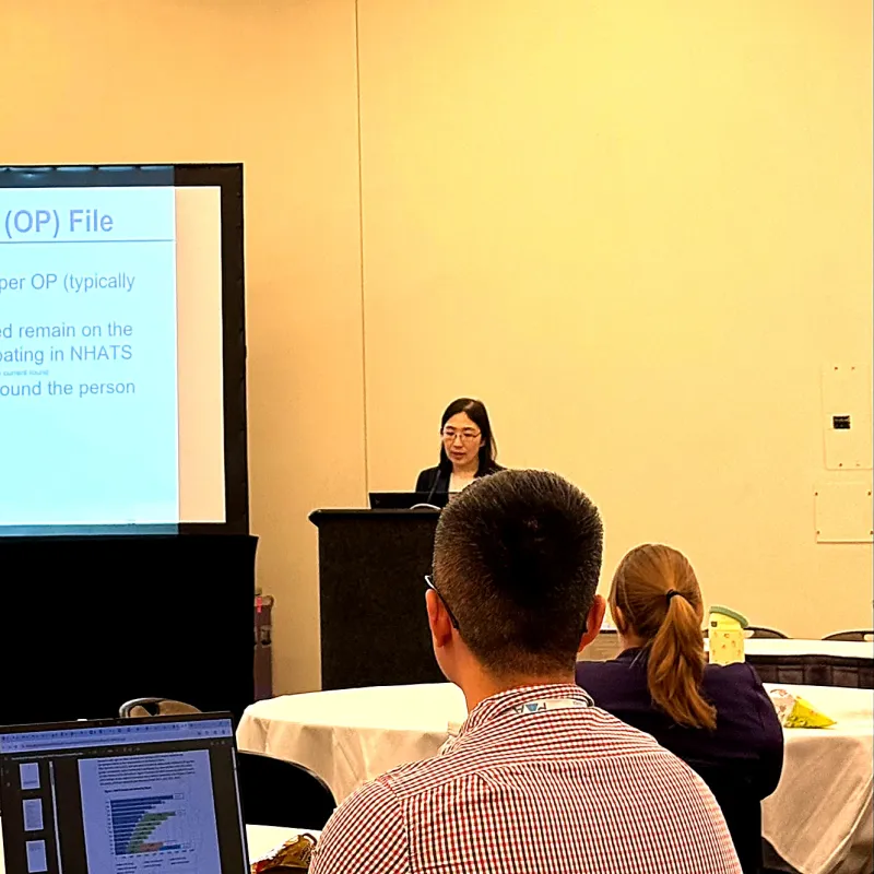 NHATS Staff presenting on NHATS data at the 2026 PAA conference in front of two audience members, who are facing away