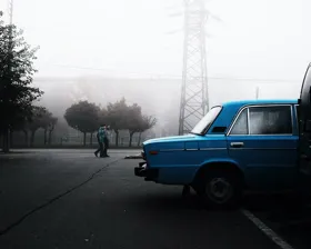 a blue car on a cloudy day