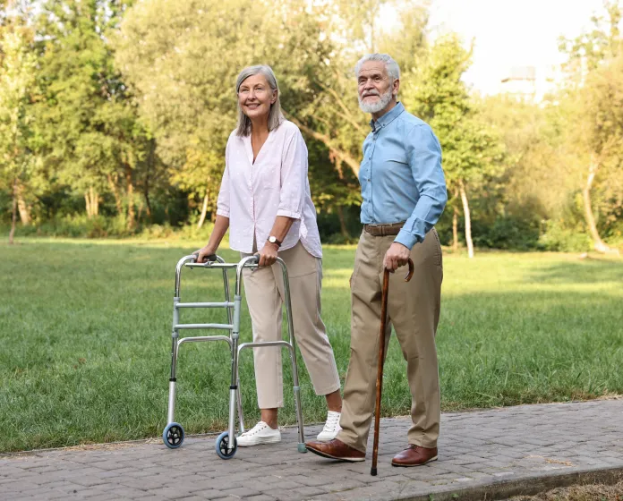 An older woman using a walker and an older man using a cane